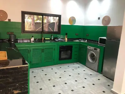 a green kitchen with a washing machine in it at Dar AZZARO in El Rhechat