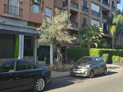 two cars parked in a parking lot in front of a building at Appartement Moderne Gueliz in Marrakech