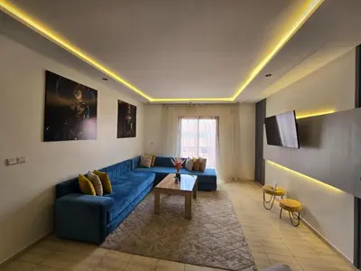 a living room with a blue couch and a table at Appartement Moderne Gueliz in Marrakech