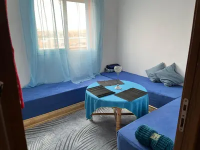 a room with two beds and a table and a window at Apparemment à Marrakech in Marrakech