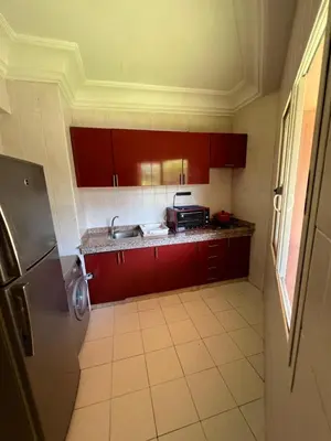 a small kitchen with red cabinets and a sink at Atlas feeling in Marrakech