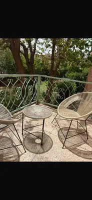 a patio with two chairs and a table and a fence at Atlas feeling in Marrakech