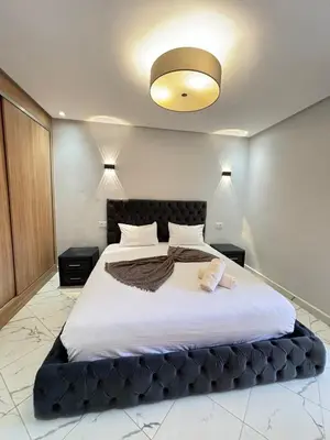 a bedroom with a large bed with a black headboard at Le cœur de la ville ocre in Marrakech