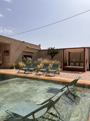 a group of chairs sitting in a swimming pool at Villa Cactus & chill - Breakfast included! in Marrakech