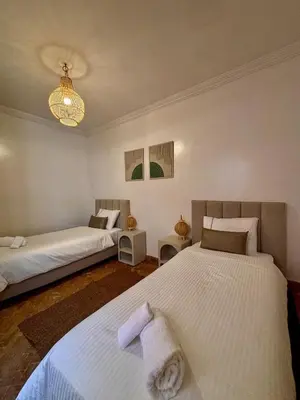 a bedroom with two beds and a chandelier at Villa Cactus & chill - Breakfast included! in Marrakech