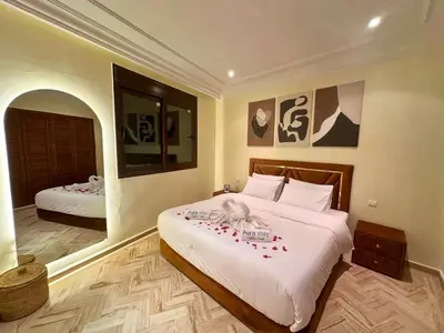 a bedroom with two beds with red flowers on them at Modern Apartment in Centre of Marrakech For Friends & Familie in Marrakech