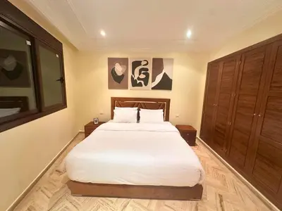 a bedroom with a large bed with white sheets at Modern Apartment in Centre of Marrakech For Friends & Familie in Marrakech