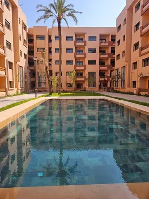 a large swimming pool in front of a building at Beautiful 5 bedroom duplex! Pool! in Oulad Akkou