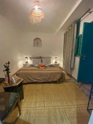 a bedroom with a bed and a chandelier at Riad Massin Marrakech in Marrakech