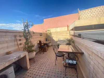 a patio with two tables and chairs on a building at Riad Massin Marrakech in Marrakech