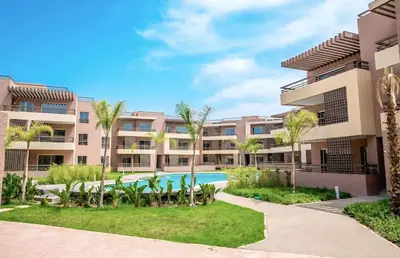an apartment complex with a swimming pool and palm trees at Riad Garden Apartement & WiFi & Pool & Parking in Marrakech