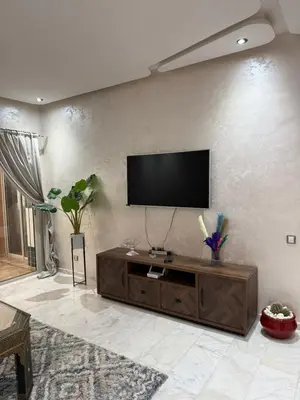 a living room with a flat screen tv on a wall at Riad Garden Apartement & WiFi & Pool & Parking in Marrakech