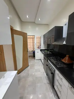 a kitchen with black and white counters and a stove at Riad Garden Apartement & WiFi & Pool & Parking in Marrakech