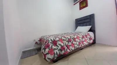 a bed in a white room with a blanket on it at Studio Confortable à Belbekkar, Marrakech in Marrakech
