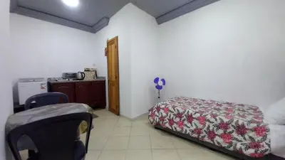 a bedroom with a bed and a table and a kitchen at Studio Confortable à Belbekkar, Marrakech in Marrakech