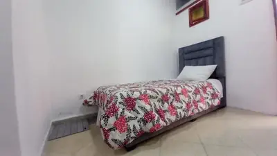 a bed in a white room with a red and white blanket at Studio Confortable à Belbekkar, Marrakech in Marrakech