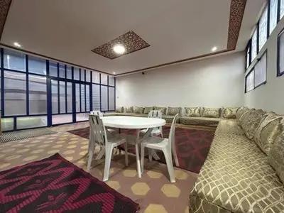 a room with a table and chairs and a couch at Maison d'hôtes Marrakech in Marrakech