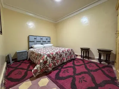 a bedroom with a bed and a large rug at Maison d'hôtes Marrakech in Marrakech