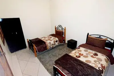 a room with two beds and a tv in it at Appartement 3 chambres - Marrakech Belbekkar in Marrakech