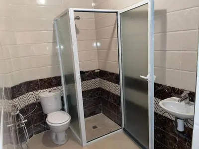a bathroom with a shower and a toilet and a sink at Appartement 3 chambres - Marrakech Belbekkar in Marrakech
