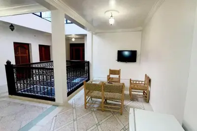 a living room with a tv and a table and chairs at Appartement 3 chambres - Marrakech Belbekkar in Marrakech
