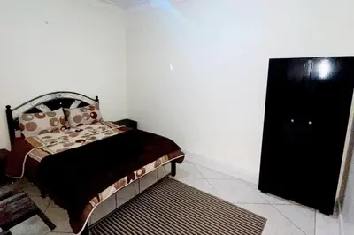 a bedroom with a bed and a black dresser at Appartement 3 chambres - Marrakech Belbekkar in Marrakech