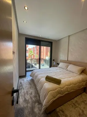 a bedroom with a large bed with a large window at Apartment for rent in Marrakech