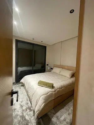 a bedroom with a large bed and a mirror at Apartment for rent in Marrakech