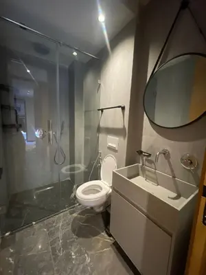 a bathroom with a toilet and a shower and a mirror at Apartment for rent in Marrakech