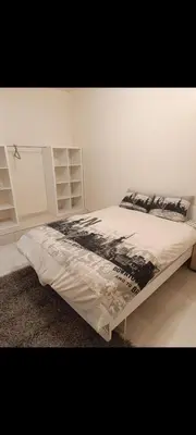 a bedroom with a bed with a black and white comforter at Chambre Marrakech 2 in Marrakech