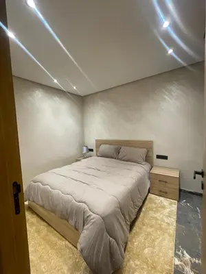 a bedroom with a large bed and lights on the ceiling at Apartment for rent in Marrakech