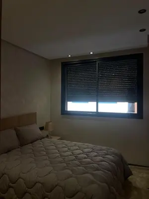 a bedroom with a large bed and a window at Apartment for rent in Marrakech