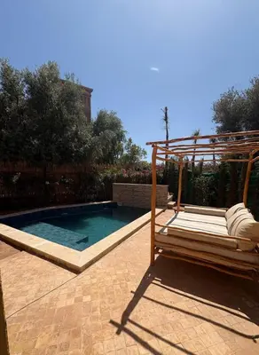 a swimming pool with a pergola next to at Riad Perles d'Annellia in Marrakech
