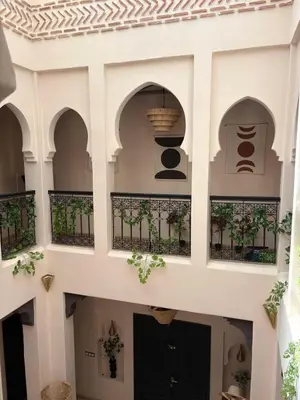 a building with arches and a black door at Riad Perles d'Annellia in Marrakech