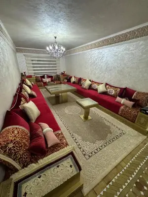 a living room with a red couch with pillows at شقة بغرفة معيشة مغربية in Marrakech