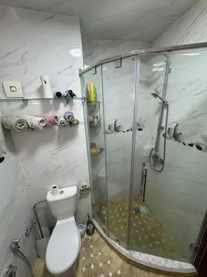 a bathroom with a toilet and a glass shower at شقة بغرفة معيشة مغربية in Marrakech