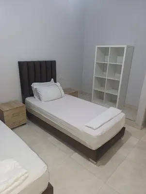 a bedroom with two beds and a book shelf at Chambre Marrakech 3 in Marrakech