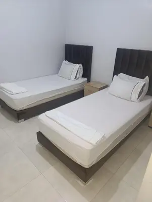 two twin beds sitting in a room withermott at Chambre Marrakech 3 in Marrakech
