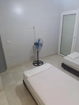 a white room with a bed and a fan at Chambre Marrakech 3 in Marrakech