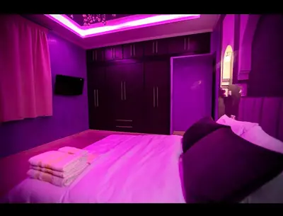 a purple bedroom with a bed with purple lighting at Spacious Moroccan Stay, Near Airport in Marrakech