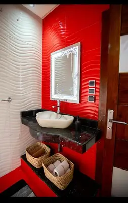 a red bathroom with a sink and a mirror at Spacious Moroccan Stay, Near Airport in Marrakech