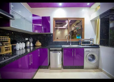 a kitchen with purple cabinets and a washing machine at Spacious Moroccan Stay, Near Airport in Marrakech