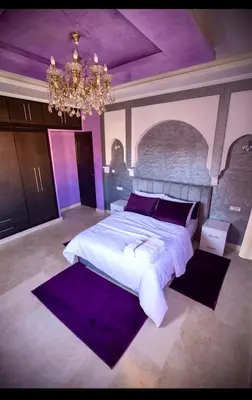 a large bedroom with a large bed and a chandelier at Spacious Moroccan Stay, Near Airport in Marrakech