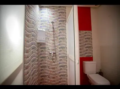 a bathroom with a toilet and a brick wall at Spacious Moroccan Stay, Near Airport in Marrakech