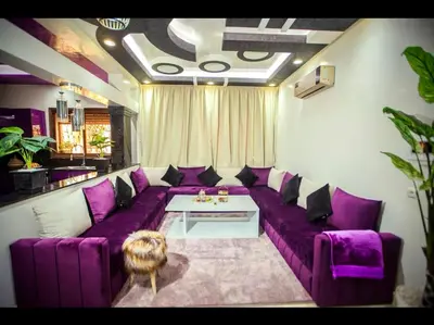 a living room with a purple couch and a table at Spacious Moroccan Stay, Near Airport in Marrakech