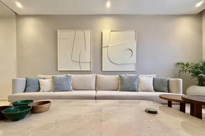 a living room with a couch and paintings on the wall at Modern 2-Bedroom Apartment in Agdal with Pool & Terrace in Marrakech