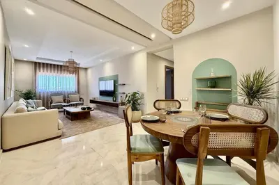 a living room with a table and a couch at Modern 2-Bedroom Apartment in Agdal with Pool & Terrace in Marrakech