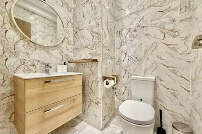 a bathroom with a toilet and a sink and a mirror at Modern 2-Bedroom Apartment in Agdal with Pool & Terrace in Marrakech