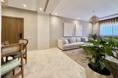 a living room with a couch and a potted plant at Modern 2-Bedroom Apartment in Agdal with Pool & Terrace in Marrakech