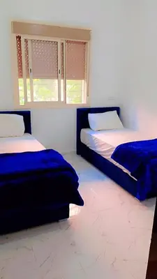 a bedroom with two beds and a window at Kawtar in Marrakech